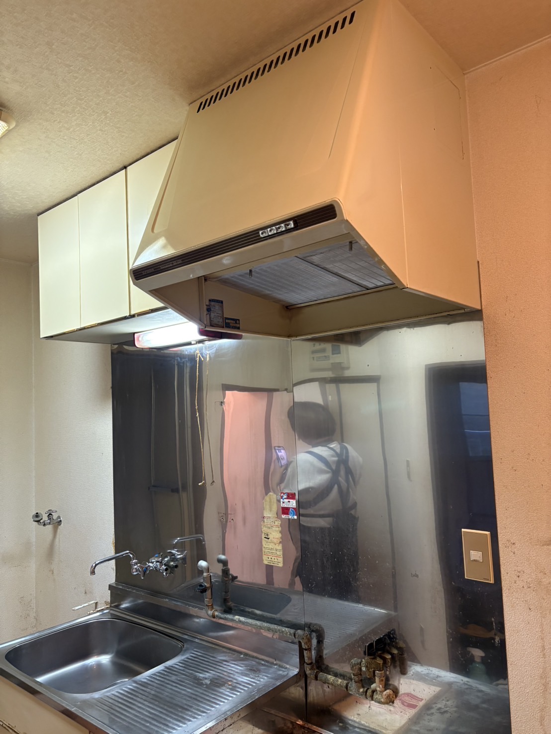 清掃後のキッチン。レンジフードと壁面の油汚れが落ちている